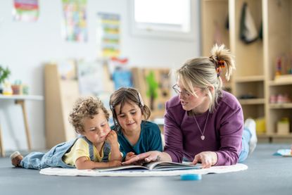 Teacher helping children read