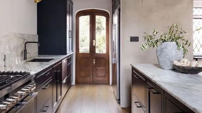 Gallery kitchen with wooden floors and dark cabinetry
