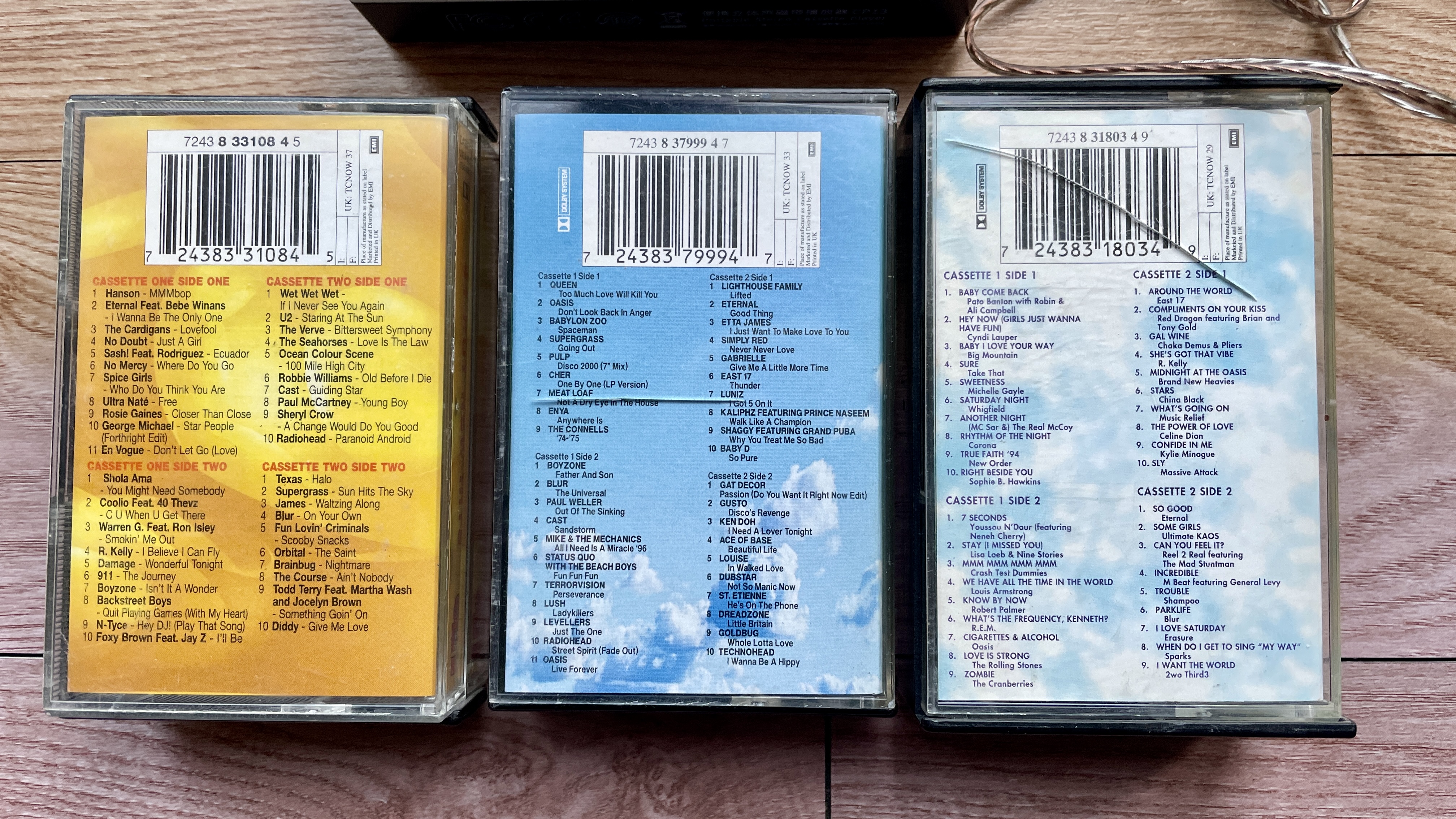 A selection of cassette tapes and a FiiO Walkman, on a wooden surface or held in a hand