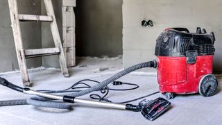 Red wet and dry vacuum inside on a building site 