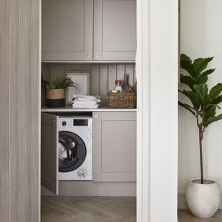 Small utility room with beige cabinets and fitted washing machine