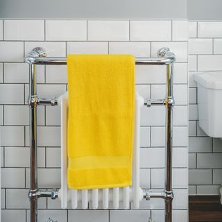 bathroom with yellow towel hanging on towel radiator