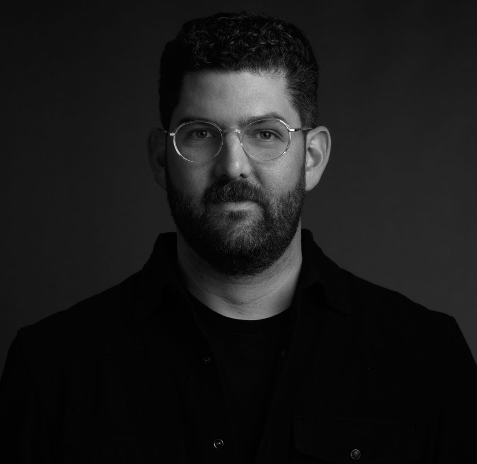 black and white image of man with beard wearing metal framed glasses