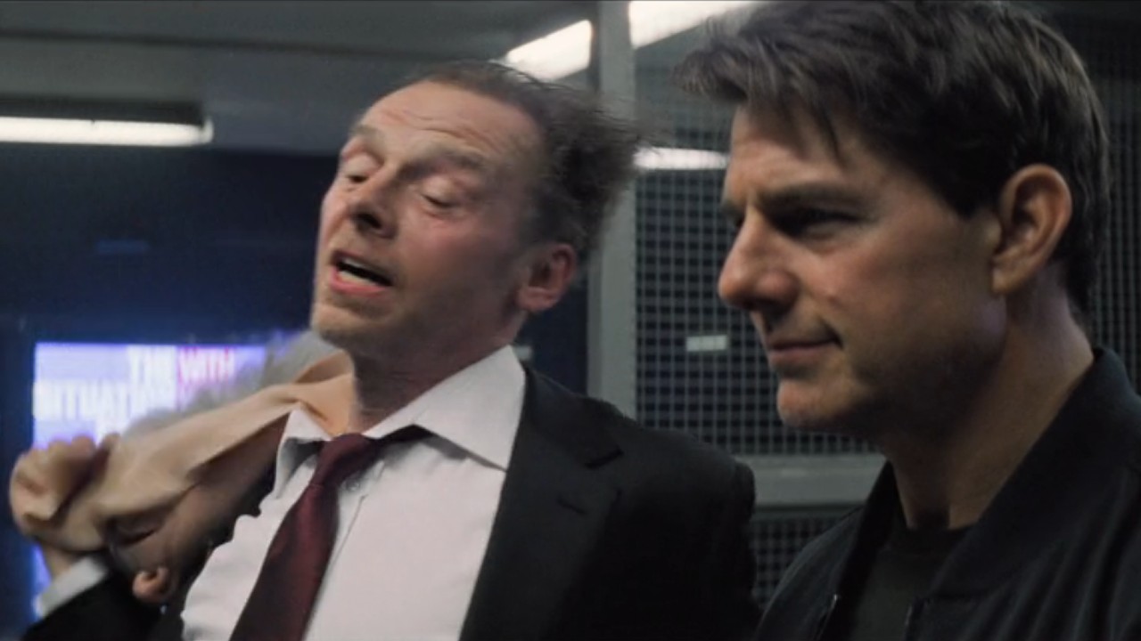 Benji pulling off a mask while standing next to Ethan in Mission: Impossible.