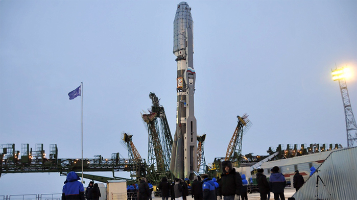 A Soyuz rocket is readied for its cold weather launch from Baikonur Cosmodrome on Dec. 28, 2011 with the latest cluster of Globalstar second-generation spacecraft. Visible at left and right is the two-piece “frame” service tower system that will be raised