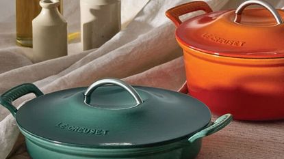 Two Le Creuset dutch ovens, one blue, one orange.