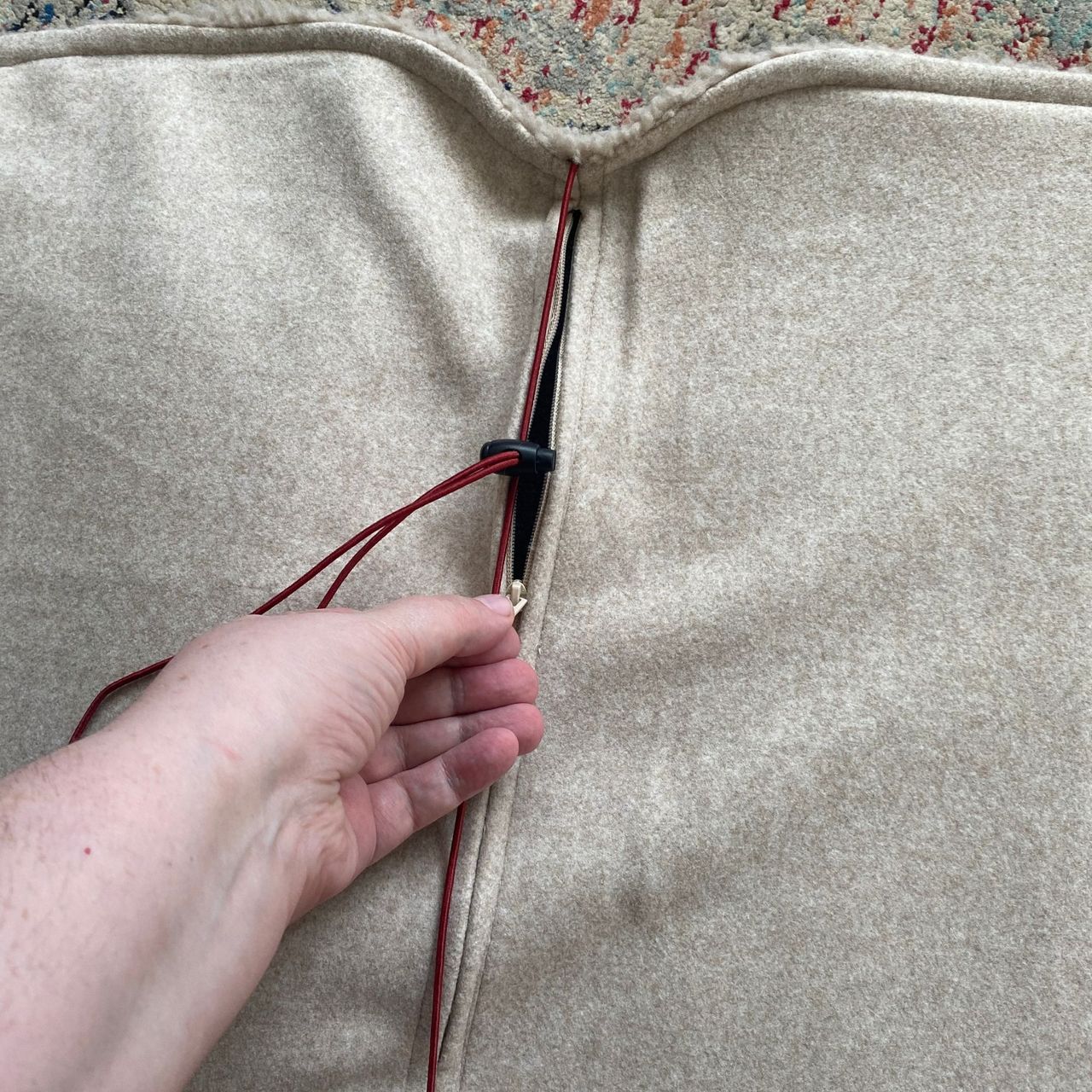 Hand opening the zip on the back of the Stoov Big Hug3
