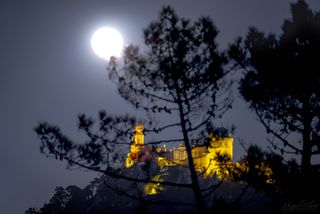 A "Super Snow Moon" shines above the Pena Palace (Palácio da Pena), a Romanticist hilltop castle overlooking the town of Sintra, Portugal.