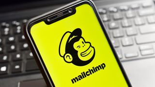 The Mailchimp logo on a smartphone in front of a keyboard