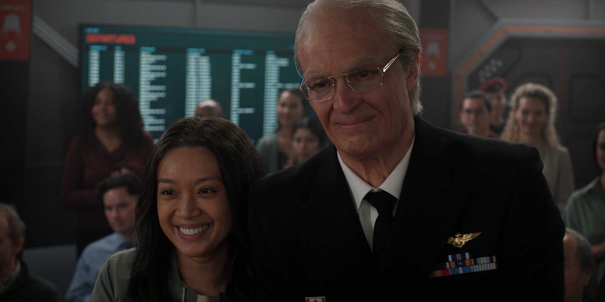 an older man in a military suit and a smiling woman