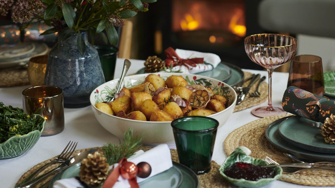 dining table dressed for Christmas with colored glassware, green ceramics and jute placemats 