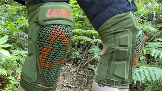 A pair of Leatt AirFlex Pro Knee Guards being worn in a jungle-like environment