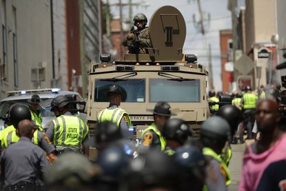 A Virginia State Police officer in riot gear keeps watch from the top of an armored vehicle in Charlottesville, Virginia. 
