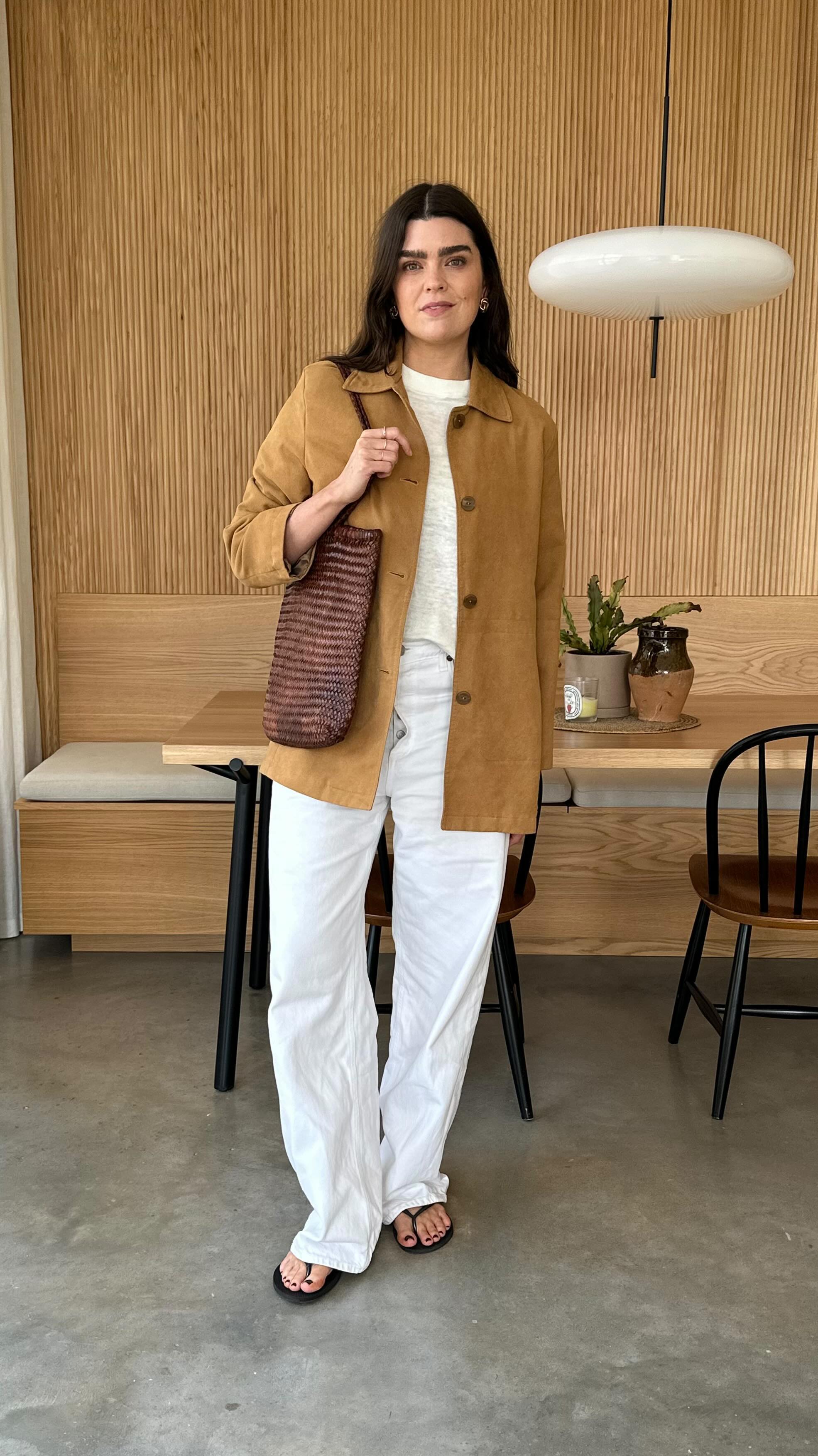 Influencer wears white jeans and black sandals.