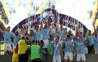 Manchester City’s Vincent Kompany (centre) lifts the Premier League trophy at Brighton last year