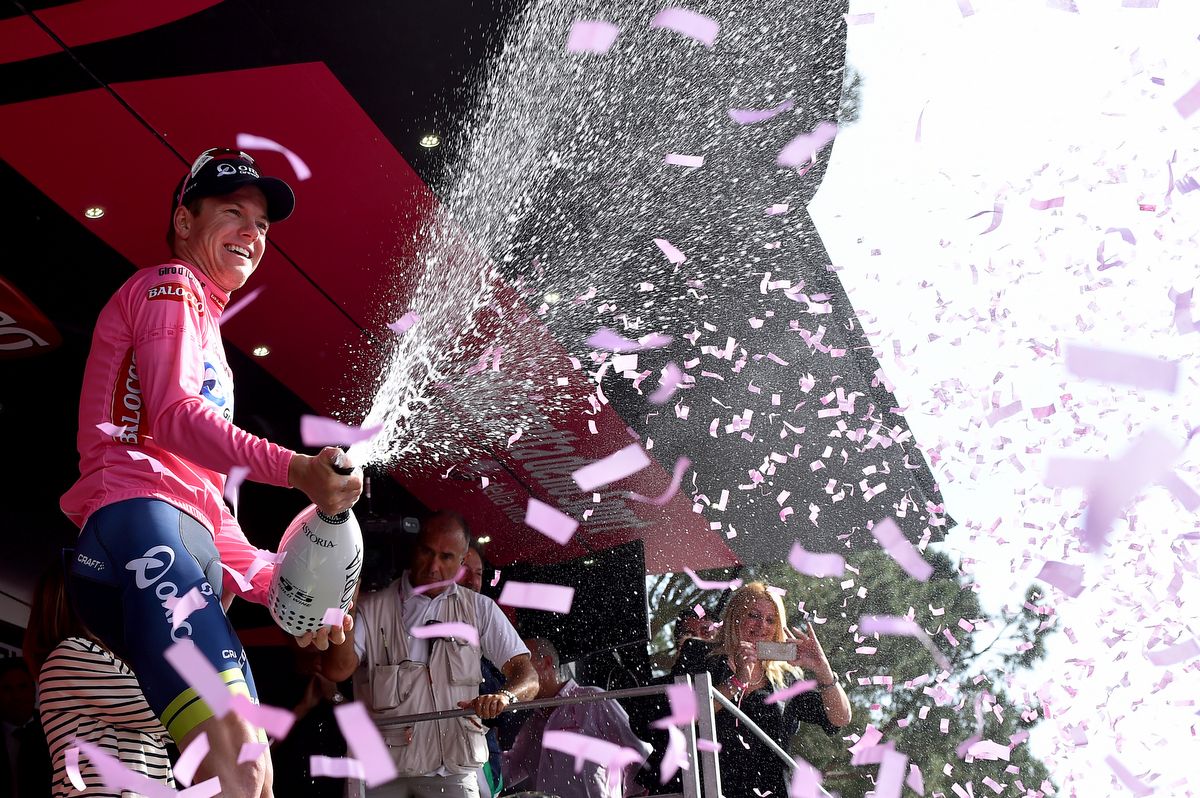 Simon Clarke soaking the photographers and crowd as he celebrates wearing the maglia rosa on the podium