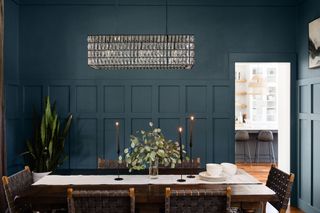 A dining room with dark blue painted walls