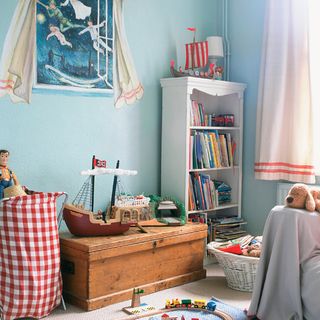 children's blue bedroom with book shelf and toys