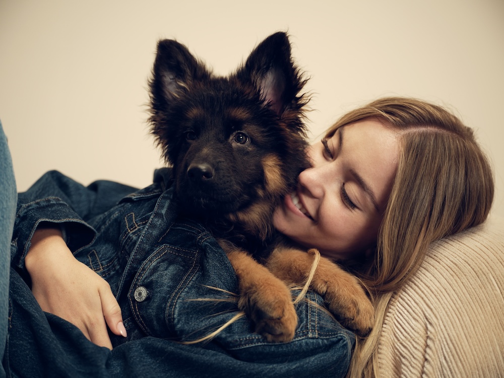 Sydney Sweeney holds her german shepherd puppy with a denim jacket
