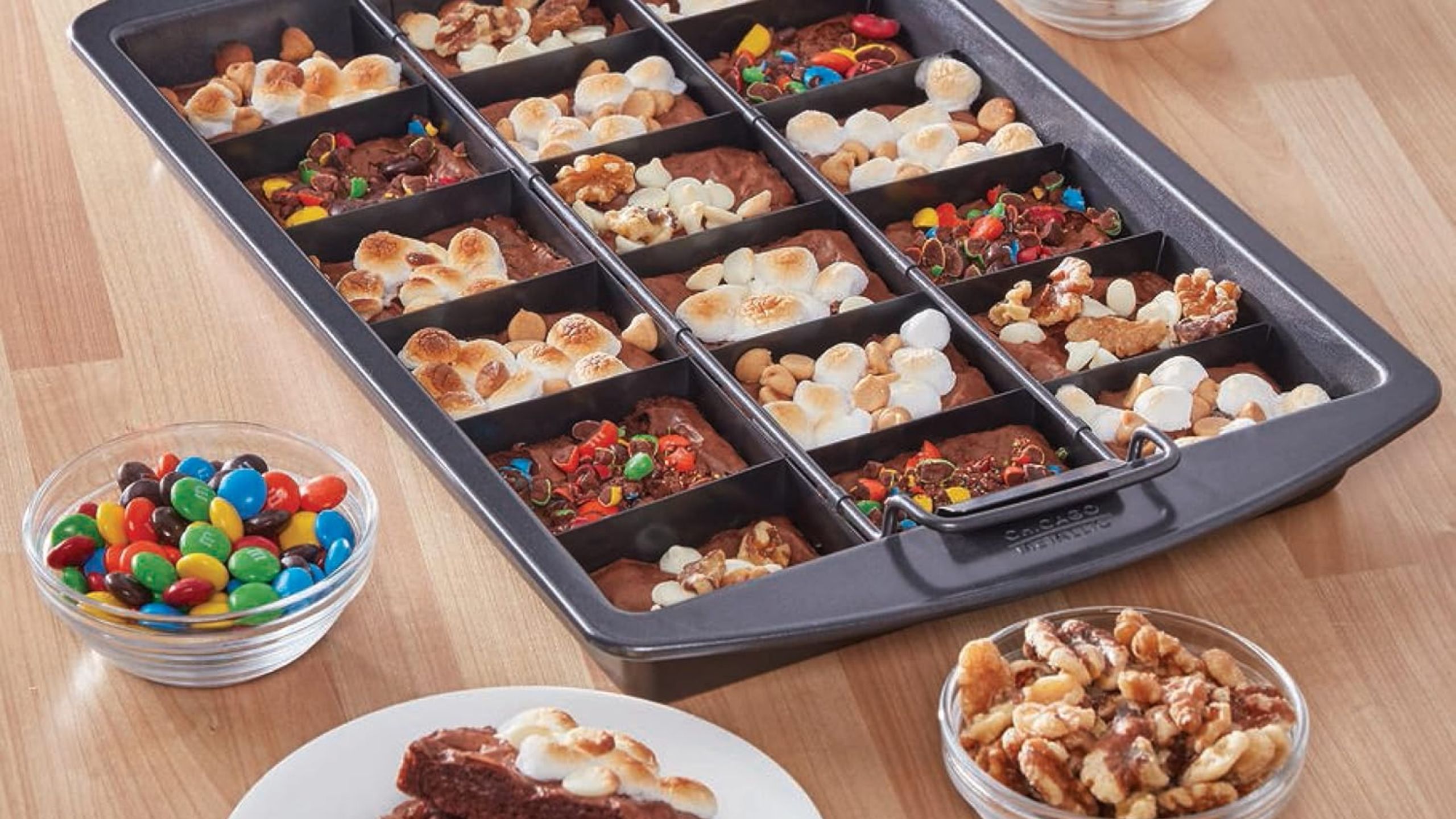 A divided brownie pan on a wooden table with brownies inside. 