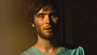 Cillian Murphy stands upset in a church in 28 Days Later.