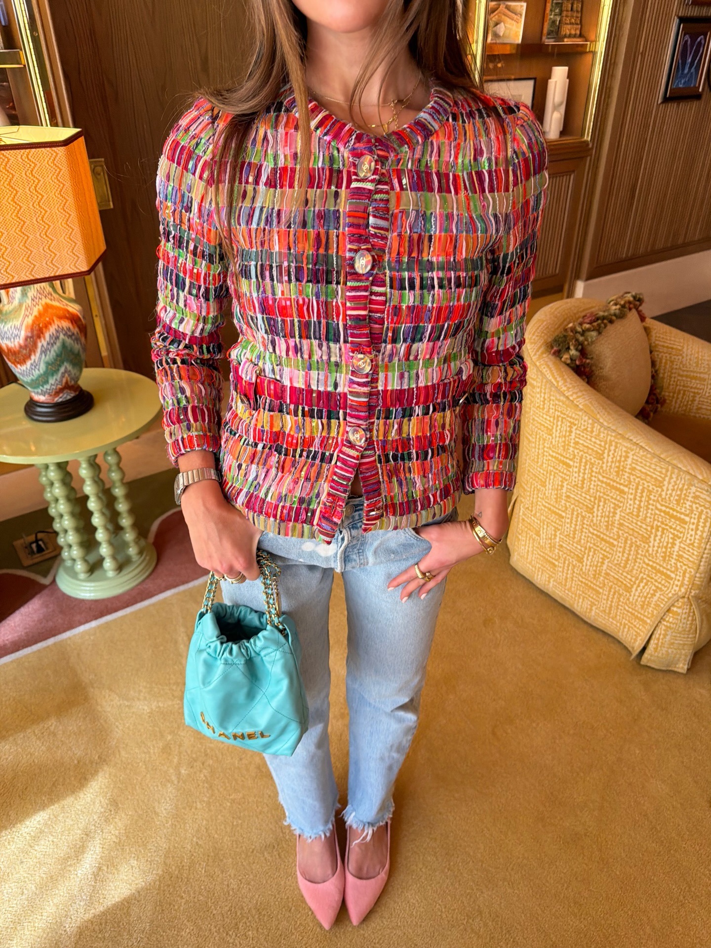 Hannah wears a tweed jacket, frayed jeans, and pink pumps.