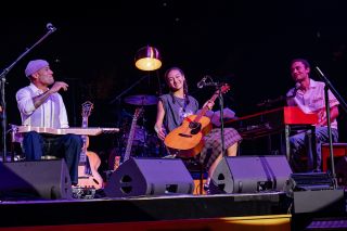 Ben Harper (left) performs onstage with his son C.J (far right) and daughter Harris, who plays the ’50s Martin 00-18 that Harper used on Harry Styles’ Boyfriends track