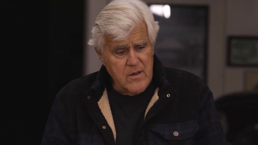 Jay Leno in jacket talking to Gabriel Iglesias in Jay Leno's Garage