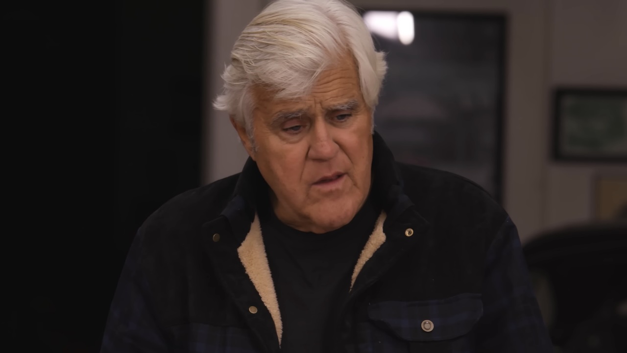 Jay Leno in jacket talking to Gabriel Iglesias in Jay Leno's Garage