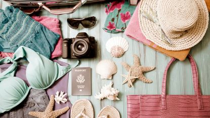 Holiday packing essentials including a camera, sunglasses, sunhat and shorts to represent booking the best holiday deals