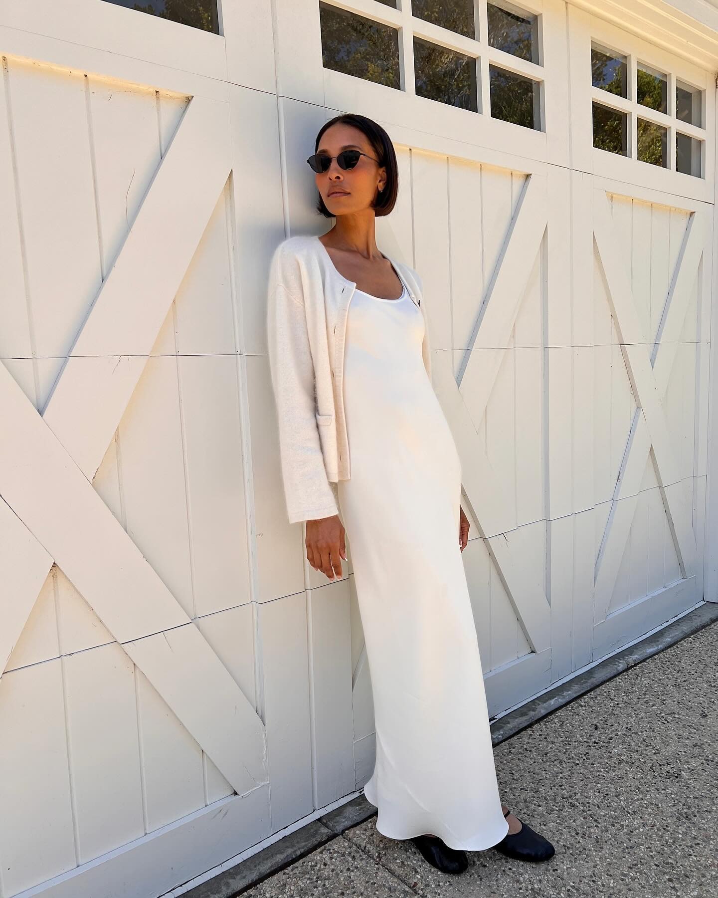 A woman wearing a white silk dress with a short, polished bob hairstyle
