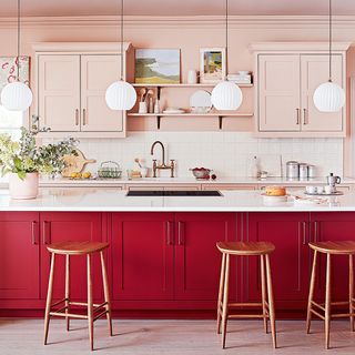Red and pink kitchen with white worktops and wall tiles