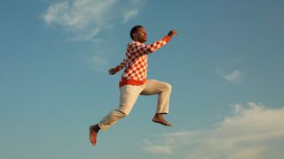 Man jumping in sky with red jumper