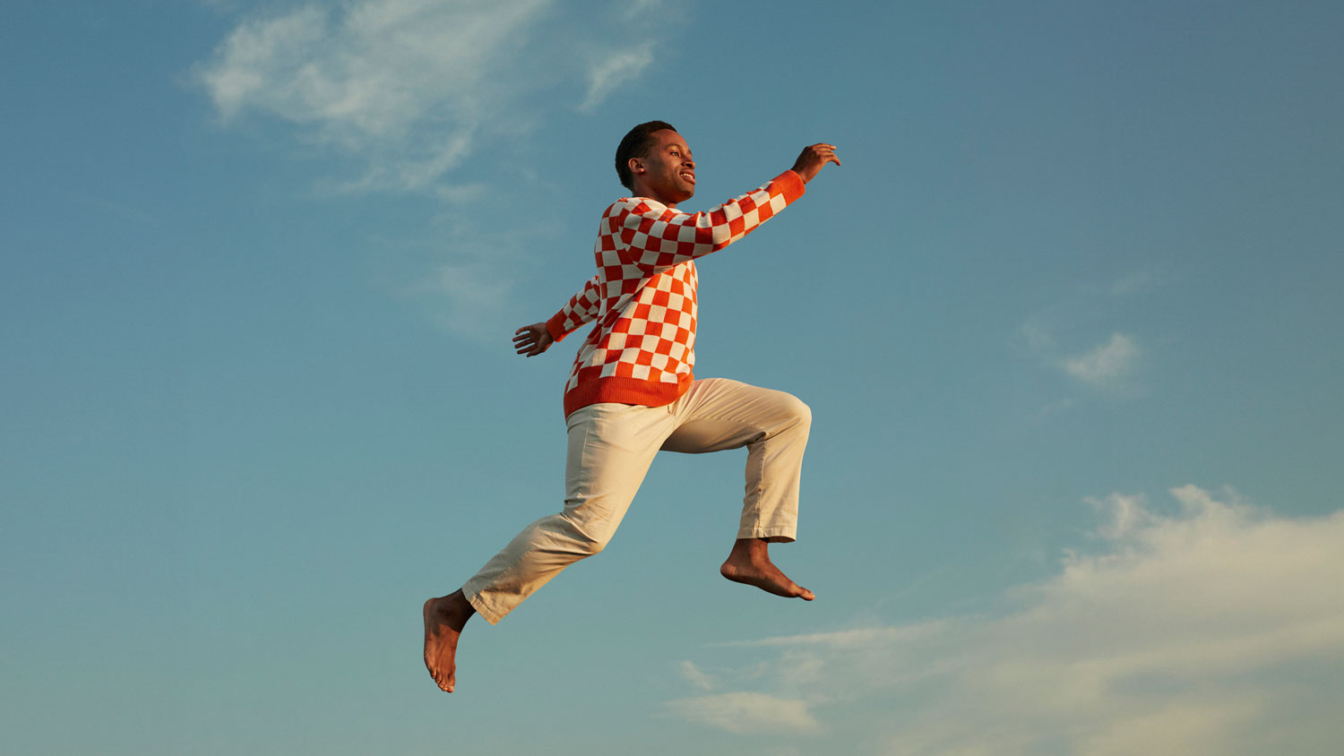 Man jumping in sky with red jumper