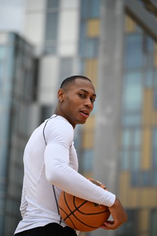 Person holding a basketball on a outdoor basketball court