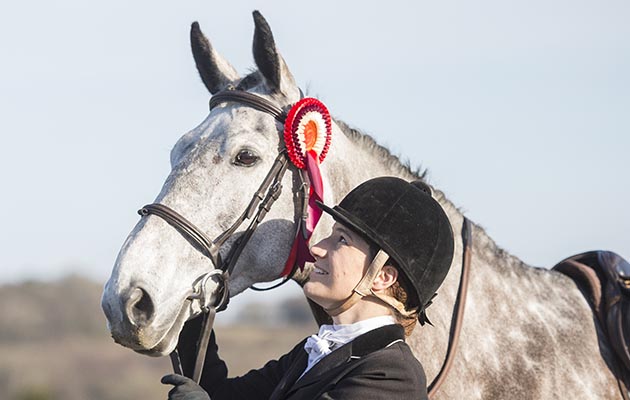Harriet Fairhurst and horse Hazel. show cover, kissing horse, bonding with horse,cuddle,rosette,showing head,grey horse,hunter