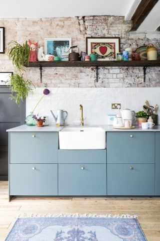 Blue kitchen with Belfast sink, open shelving and raw brick wall