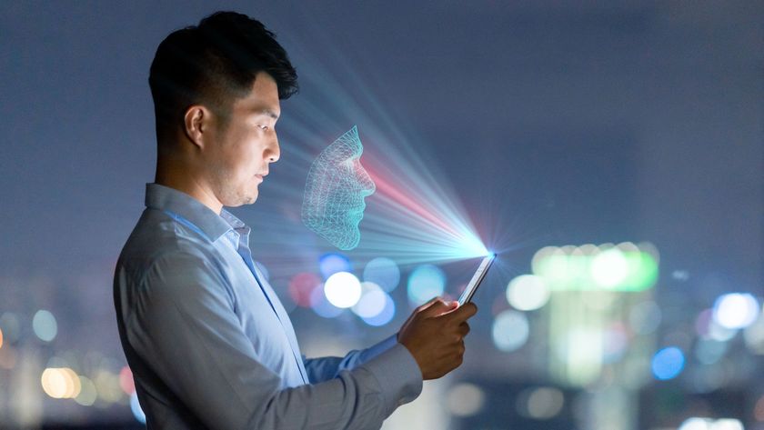 Young man using facial recognition technology with mobile phone