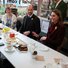 Prince William and Princess Kate sitting at a table with a woman at a cafe