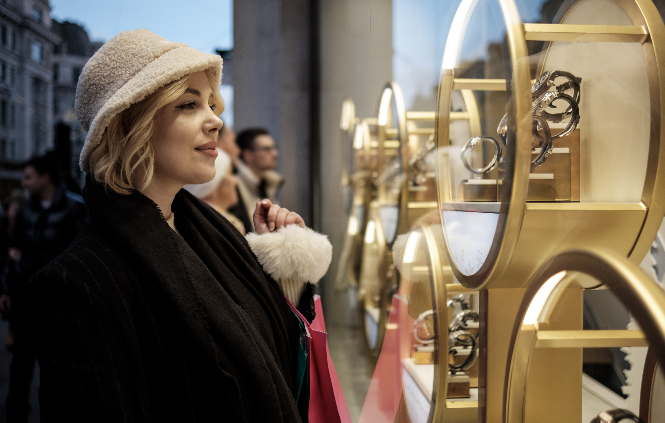 Woman looking in a jewellery shop window buying luxury goods
