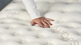 One of our review team places her hand on top of the Saatva Classic mattress during a temperature control test