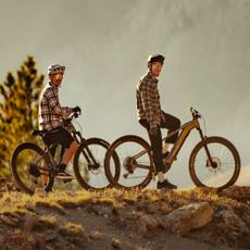 Two men riding electric Aventon mountain bikes outdoors