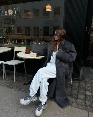 Fashion influencer @pernilleteisbaek wearing a chic winter outfit with controversial technical sneaker trend.