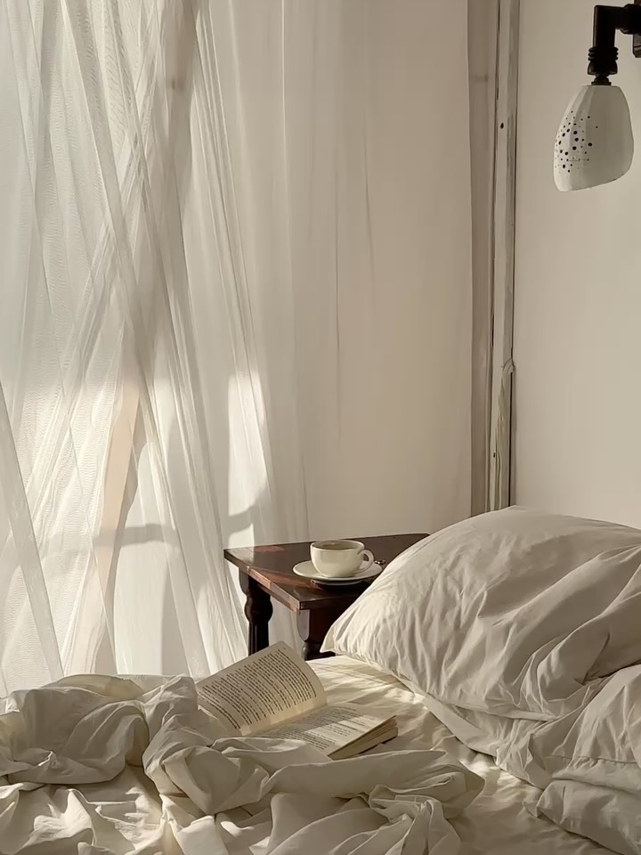 Relaxing in bed with a book and coffee