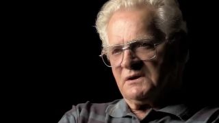 The real Donald Malarky in an interview in front of a black background in Band of Brothers