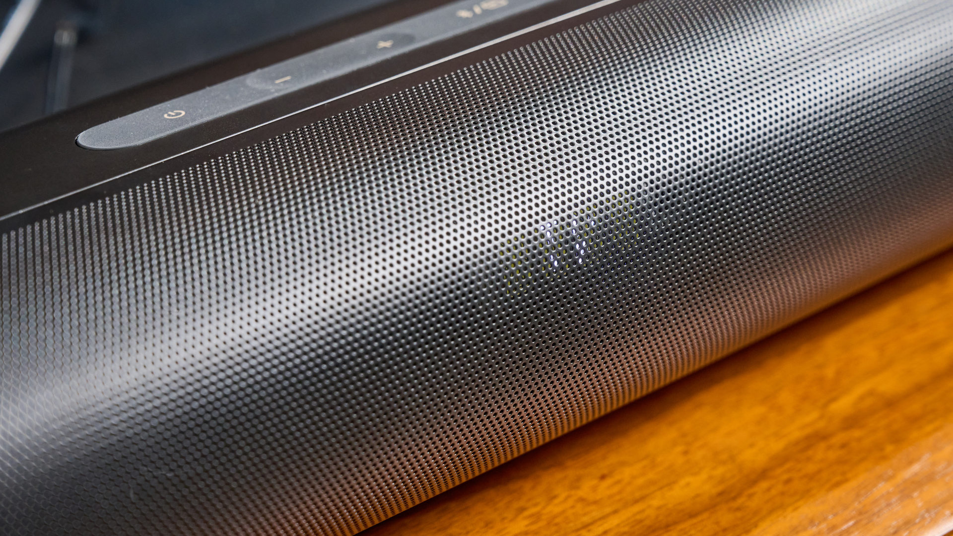 the creative stage pro soundbar and subwoofer, a super-budget home cinema system with 2.1 channels and a remote control photographed on a wooden tv stand with a TV behind