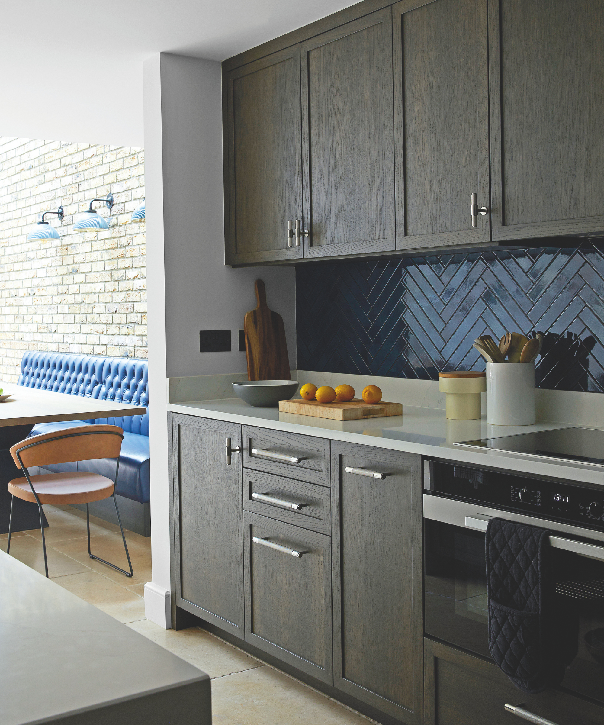Dark wood kitchen with a blue tiled splashback.