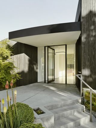 Entrance with curves and greenery at Round House by Feldman architecture