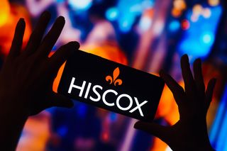 Hiscox logo displayed on a smartphone with branding pictured in the background