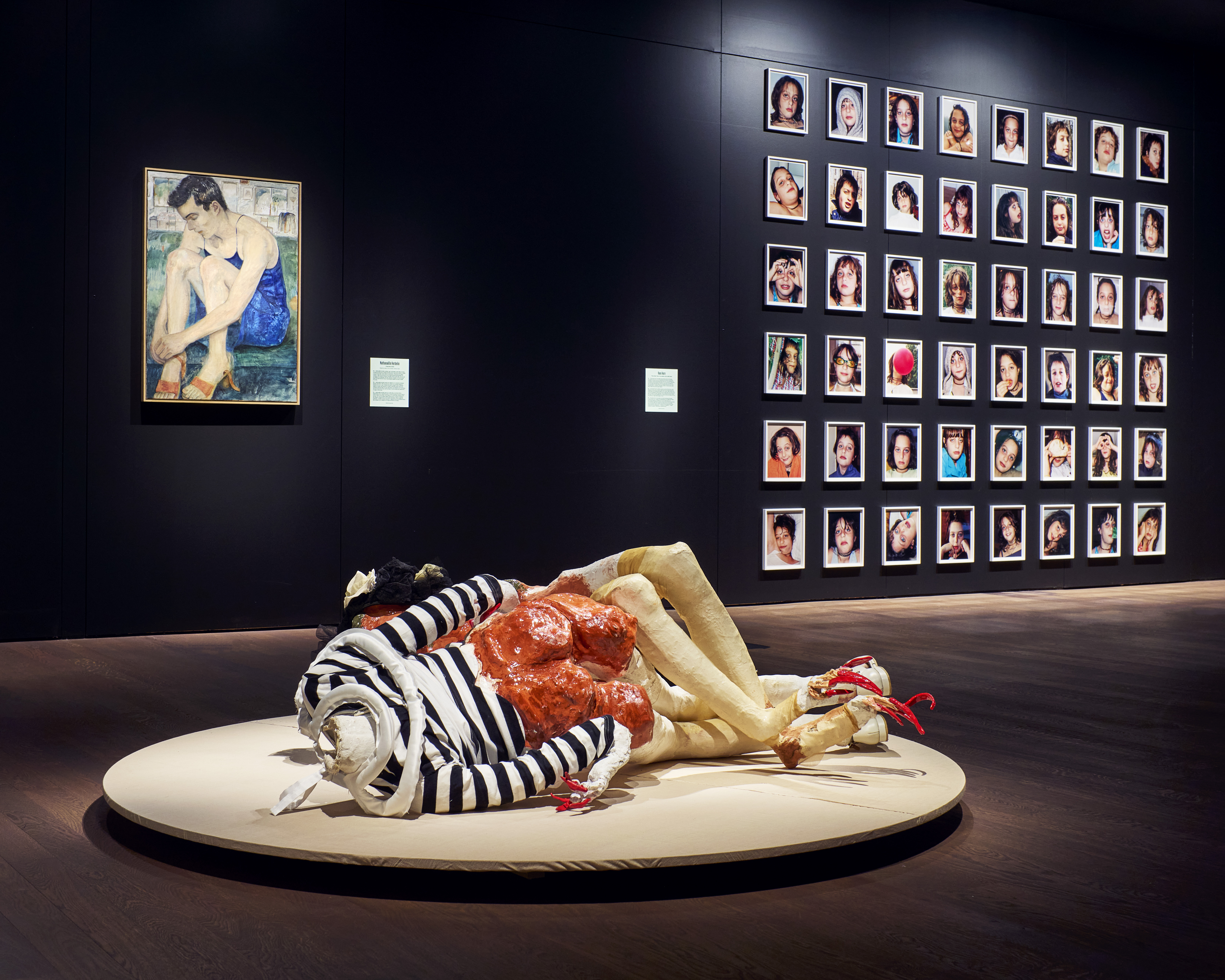 a sculpture of a body wearing a striped black and white shirt contorted at a museum exhibit for girls on boredum rebellion and being in between at momu antwerp
